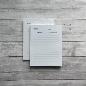 May include: Two white notepads with lined paper and black text. The top notepad says "NOTE" and "date". The bottom notepad says "NOTE", "important", and "not important".