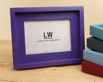 May include: A purple picture frame with a white mat and the text "LW LAURELTON WORKSHOP" inside.