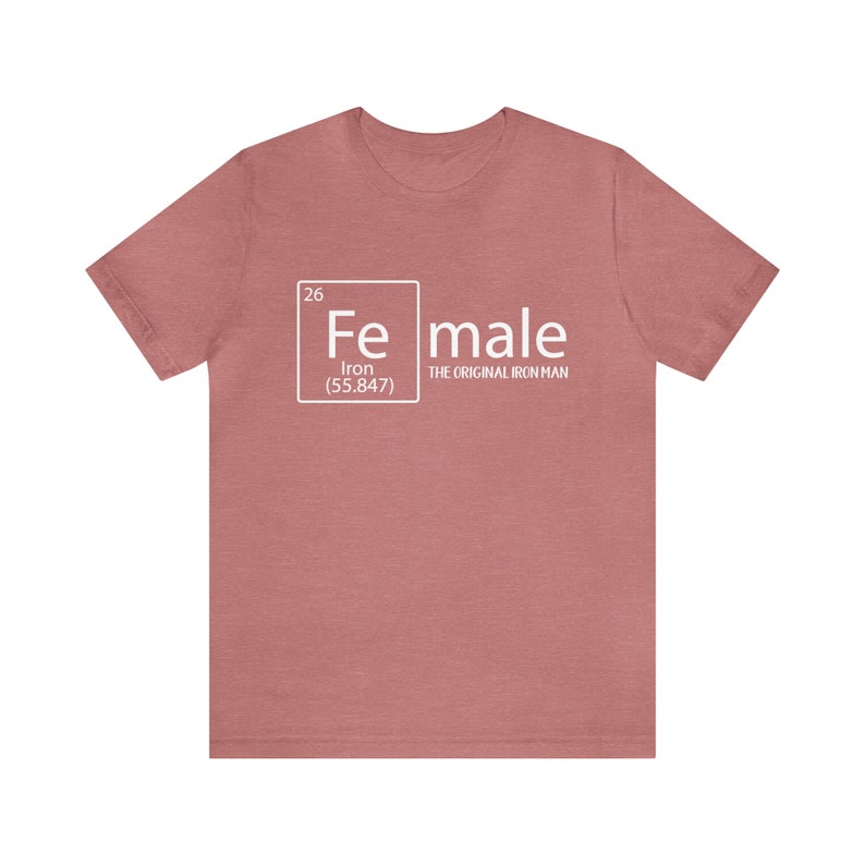 May include: A heather pink t-shirt with a white graphic of the periodic table element for iron, with the word "female" next to it and the text "The Original Iron Man" underneath.