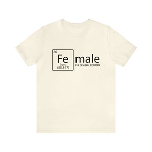 May include: A white t-shirt featuring a black graphic of a periodic table element. The element is iron, with the symbol "Fe", atomic number 26, and atomic weight 55.847. The text "male" is written next to the element box, with the words "The Original Iron Man" underneath.