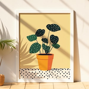May include: A framed print of a green plant with white polka dots on the leaves in a yellow pot. The plant is on a white and black polka dot background.