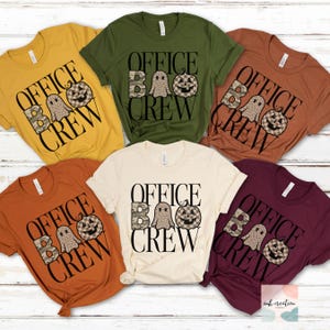 May include: Five short-sleeved t-shirts in mustard yellow, olive green, burnt orange, cream, and maroon. Each shirt features the black text "OFFICE CREW" with a camouflage letter B, a leopard print ghost, and a checkered pumpkin graphic.
