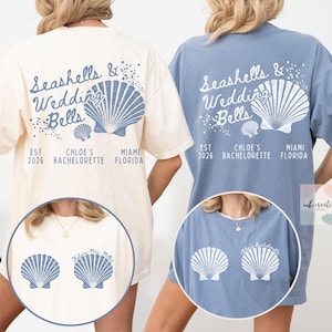 May include: Two t-shirts, one cream and one blue, feature a seashell design and the text "Seashells & Wedding Bells." The cream shirt has a front graphic with "Future Mrs. Miller." The blue shirt has "Chloe's Bachelorette" on the front.