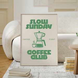May include: A beige poster with green text that reads "Slow Sunday Coffee Club". The poster features a green illustration of a coffee pot and a coffee cup.