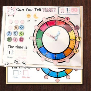 May include: A colorful learning tool for teaching time. The clock face has a colorful ring with numbers 1-60, and a smaller ring with numbers 1-12. The clock hands are movable. The time is 1:50. There are also number tiles for children to use to practice telling time.