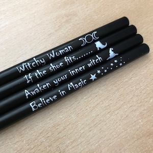 May include: Four black pencils with white text and symbols. The text on the pencils reads "Witchy Woman", "If the shoe fits...", "Awaken your inner witch", and "Believe in Magic".