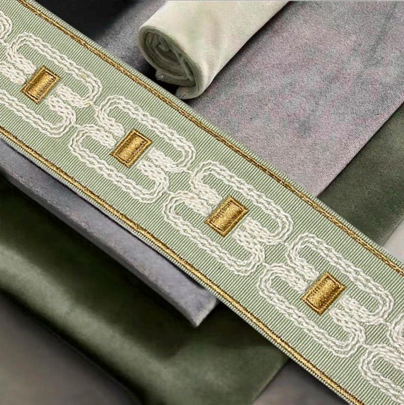 Pode incluir: Um close-up de uma guarni&ccedil;&atilde;o de tecido verde e branco com um padr&atilde;o de corrente dourada. A guarni&ccedil;&atilde;o &eacute; tecida com uma textura sutil e apresenta um desenho repetitivo de correntes entrela&ccedil;adas.