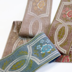 May include: Three different trims of fabric ribbon with floral patterns. The ribbons are in shades of brown, blue, and white.