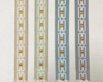 May include: Four samples of trim with a white background and a repeating geometric pattern in gold and white. The trim is 2.4 inches wide. The trim is labelled A, B, C, and D.
