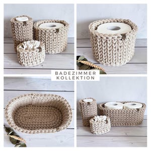 May include: A collection of beige crochet bathroom organizers, including a toilet paper holder, a cotton swab holder, and a tall, cylindrical container. The text "BADEZIMMER KOLLEKTION" is displayed on a white background. The items are arranged on a light wooden surface.