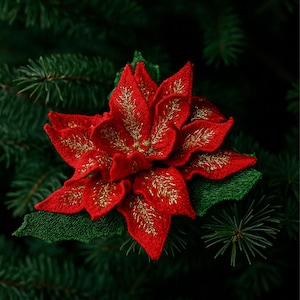 以下が含まれることがあります： 金色の刺繍が施された鮮やかな赤いポインセチアの花。緑色の松葉を背景に、お祝いのテーマを表現しています。花の繊細な花びらが特徴です。