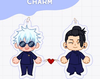 Puede incluir: Un dije en forma de corazón con dos personajes de dibujos animados conectados por un corazón rojo. Un personaje tiene cabello blanco y gafas de sol, el otro tiene cabello negro. El dije tiene el texto "SATOSUGU HEART CHARM" en la parte superior.