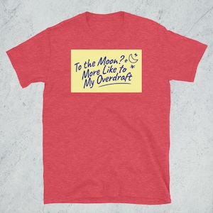 Könnte beinhalten: Rotes melierter T-Shirt mit einem gelben Haftnotiz, auf dem "To the Moon? More like to My Overdraft" mit einem Halbmond und Sternen steht.