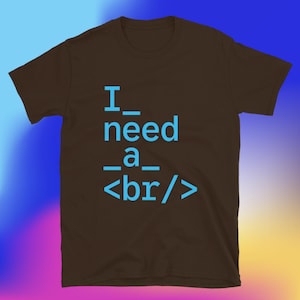 May include: A brown t-shirt with the text "I need a <br/>" in blue. The text is centered on the front of the shirt. The shirt has short sleeves and a crew neck.