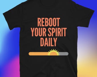 May include: Black t-shirt with the text "REBOOT YOUR SPIRIT DAILY" in orange. Below the text is a graphic of a sun rising over a bar. The shirt is made of a soft material.