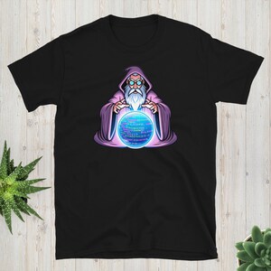 Może przedstawiać: Czarny T-shirt z kreskówkowym wizerunkiem czarodzieja z długą białą brodą i okularami trzymającego świecącą fioletową kryształową kulę z kodem w środku. Czarodziej ma na sobie fioletową szatę.