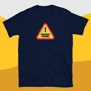 Peut inclure: Un t-shirt bleu marine avec un panneau d'avertissement jaune et rouge qui indique "FICHIER INTROUVABLE" en texte noir.