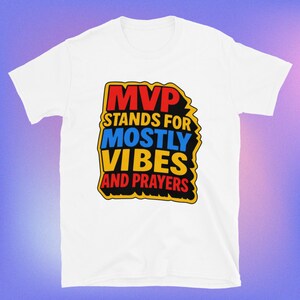 Könnte beinhalten: Weißes T-Shirt mit dem Text "MVP STANDS FOR MOSTLY VIBES AND PRAYERS" in einer farbenfrohen, fetten Schriftart. Der Text ist schwarz umrandet und vor einem gelben Hintergrund platziert. Das T-Shirt hat kurze Ärmel und einen Rundhalsausschnitt.