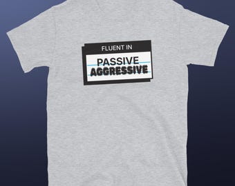 May include: Gray t-shirt with a black and white graphic that says "Fluent in Passive Aggressive".