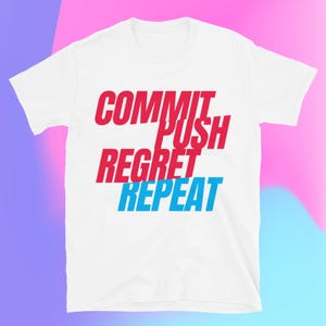 Puede incluir: Camiseta blanca con las palabras "COMMIT PUSH REGRET REPEAT" en letras de bloque rojas y azules. La camiseta tiene mangas cortas y cuello redondo. El fondo es un degradado de rosa y morado.