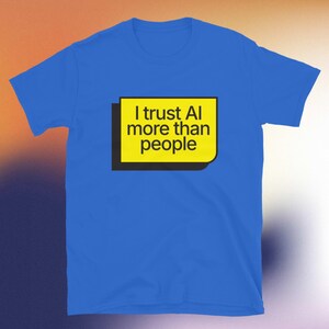 Op de afbeelding: Koning blauw t-shirt met de tekst "I trust AI more than people" in zwarte letters op een gele rechthoek met een zwarte rand. Het t-shirt heeft een ronde hals en korte mouwen.