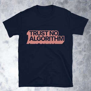 Może przedstawiać: Granatowa koszulka z napisem "TRUST NO ALGORITHM" w stylizowanej, łososiowej czcionce. Grafika jest umieszczona centralnie na przodzie koszulki. Koszulka jest wykonana z miękkiego materiału.
