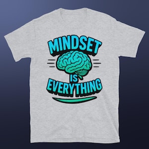 Può includere: Maglietta grigia con una grafica blu e verde di un cervello e il testo "Mindset is Everything".
