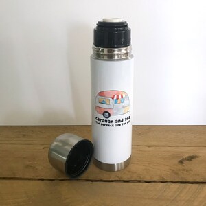May include: White stainless steel travel mug with a black lid and a cartoon illustration of a camper van with the text "caravan and tea The perfect life for me".