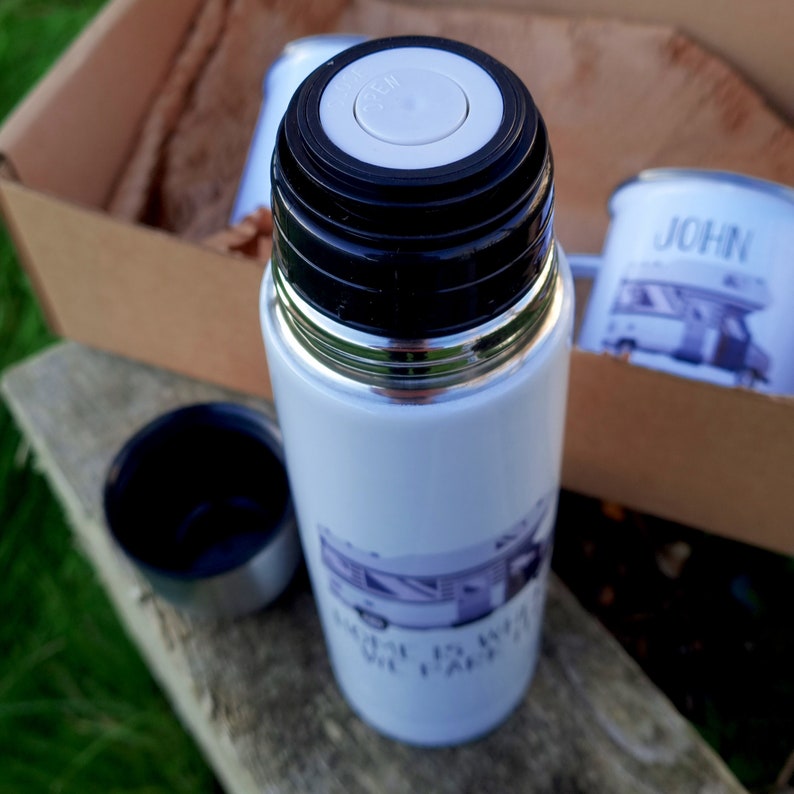 May include: White insulated travel mug with a black lid and a black and white image of a camper van with the text "Life is what you make it" printed on the side.