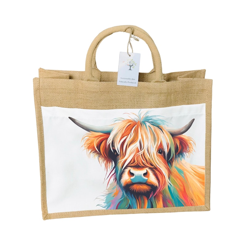 May include: A jute tote bag with a colorful illustration of a Highland cow on the front. The bag has a white background and the text "Handmade Fair Trade Product" on a tag.