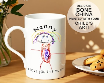 May include: White ceramic mug with a drawing of a person and the word "Nanny" in black. The mug has the text "I love you this much!" and "DELICATE BONE CHINA PRINTED WITH YOUR CHILD'S ART!"