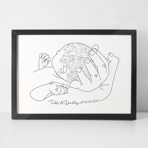 May include: Black and white line art drawing of a baby's head resting in a hand, with the text "Teddy & Daddy est. 02.04.2022".