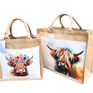 May include: Two jute tote bags with colorful Highland cow illustrations. The smaller bag features a cow with a floral crown, while the larger bag has a cow with a colorful, abstract design.