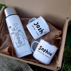 Op de afbeelding: Een witte cadeaudoos met een witte thermoskan, een witte mok met de tekst "Josh lovin' life" en een witte mok met de tekst "Sophia festival queen".
