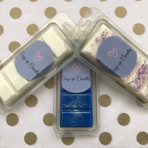 May include: Three wax melts in clear plastic packaging. The wax melts are in the scents: Lavender, Vanilla, and Ocean Breeze. Each wax melt has a label that says "Cosy up Candles" with a heart.