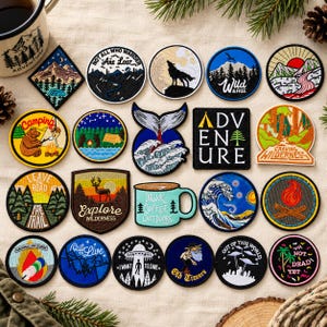 May include: A collection of twenty-two embroidered patches featuring various outdoor and nature-themed designs, including mountains, forests, wildlife, camping scenes, a coffee mug, a whale tail, a UFO, and text such as Adventure, Wild & Free, and Explore.