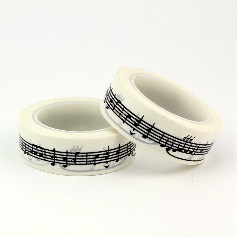 May include: Two rolls of white washi tape with black musical notes printed on them.