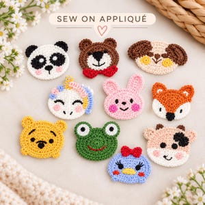 May include: A collection of ten crocheted animal face appliques including a panda, brown bear with a red bow, dog, unicorn, pink rabbit, fox, yellow bear, green frog, cow, and a blue duck with a red bow, labelled with the text SEW ON APPLIQUÉ.