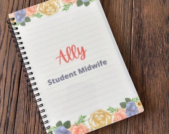May include: A spiral-bound notebook with lined pages. The cover features a floral design with pink, yellow, and blue flowers. The name "Ally" is written in coral script, with "Student Midwife" below in gray.