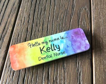 May include: A rainbow watercolor name tag with the text "Hello my name is... Kelly Dental Nurse".