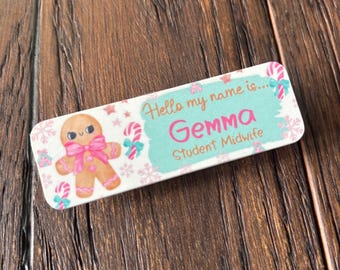 May include: A rectangular name tag with a gingerbread man and the text "Hello my name is... Gemma Student Midwife." The tag has a light blue background with pink and white accents, including snowflakes and candy canes.