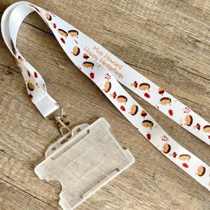 May include: White lanyard with a hedgehog pattern and the text "Miss Howard Happy Hedgehogs". A clear plastic ID card holder is attached to the lanyard.