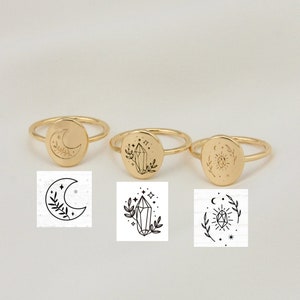 Può includere: Tre anelli d'oro con diversi design. Il primo anello presenta una luna crescente con un design floreale. Il secondo anello presenta un cristallo con un design floreale. Il terzo anello presenta un sole con un design floreale.