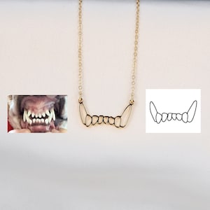 Puede incluir: Un collar dorado con un colgante con forma de dientes. La cadena es fina y el diseño es minimalista. La imagen también incluye una foto de dientes de perro y un dibujo lineal de dientes.