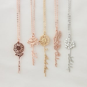 May include: Four delicate gold, rose gold, and silver necklaces with flower charms and personalised names. The names are "Love", "Wildflower", "Alice", and "Ellie".