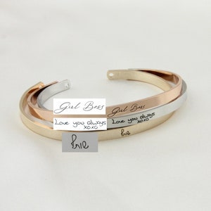 May include: Three gold, silver, and rose gold bangle bracelets with engraved text. The top bracelet reads "Girl Boss". The middle bracelet reads "Love you always xoxo". The bottom bracelet reads "Love you always xoxo" and "Brie".
