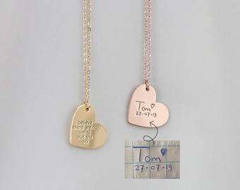 May include: Two gold heart-shaped necklaces. One necklace has the inscription "believe there are no limits but the sky" on the heart pendant. The other necklace has the inscription "Tom 27-07-19" on the heart pendant.