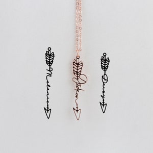 May include: Three gold arrow necklaces with the names "Melannie", "Stickan", and "Darcy" written on them.
