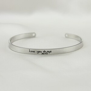 May include: Silver bangle bracelet with the inscription "Love you always xoxo" engraved on the front.