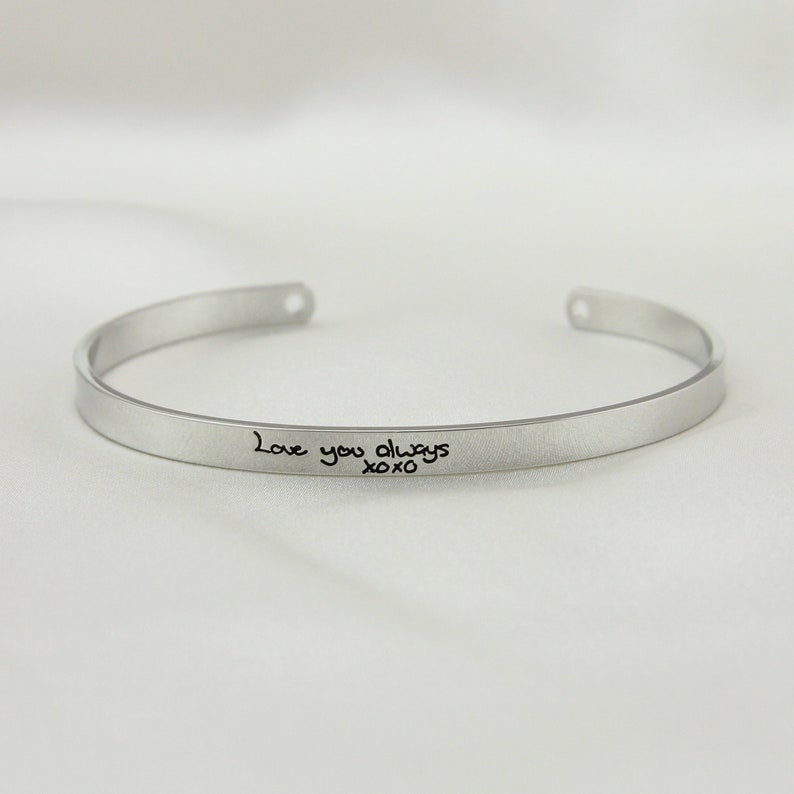 May include: Silver bangle bracelet with the inscription "Love you always xoxo" engraved on the front.